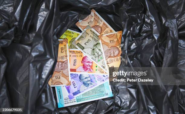 rupees in black plastic bag. - money-talks-englische-redewendung stock-fotos und bilder