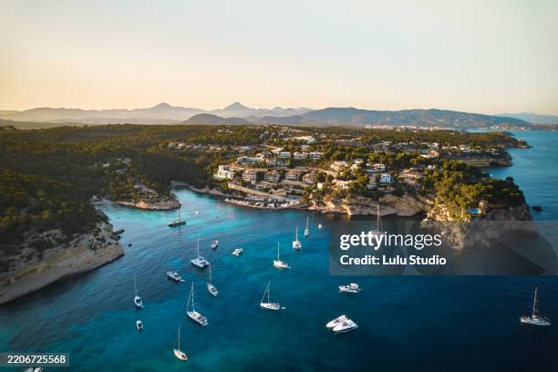 sailboats and yachts mooring near the coast of cala anguila in majorca at sunset - majorca stock pictures, royalty-free photos & images