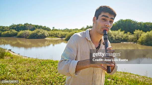 flute player riverside harmony - classical musician stock pictures, royalty-free photos & images