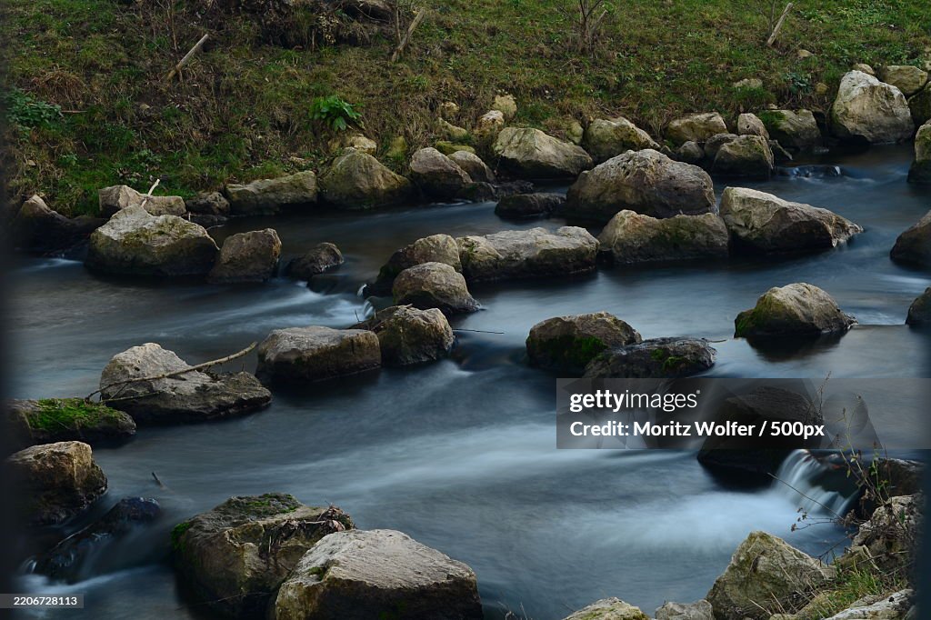View of an small river with long exposure floating water rocks nature daylight,Germany