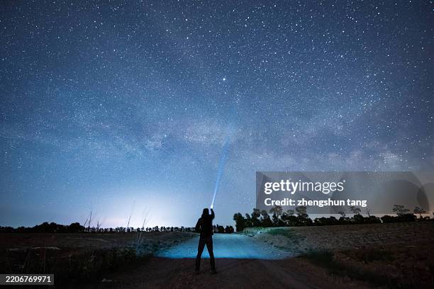 stargazer illuminating the night under the milky way - irradiation stock pictures, royalty-free photos & images
