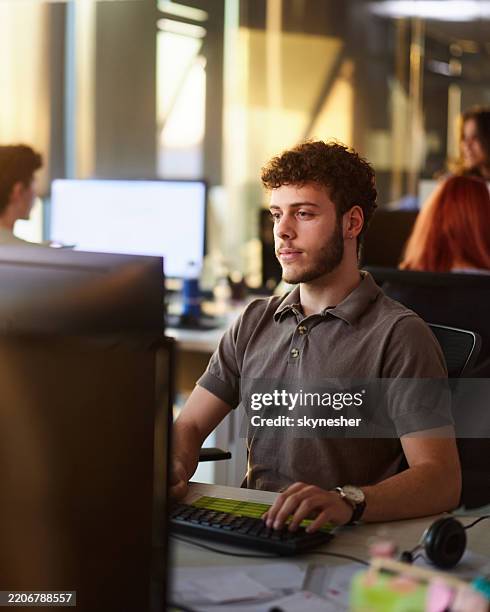 male programmer working on desktop computer in the office. - web programmer stock pictures, royalty-free photos & images
