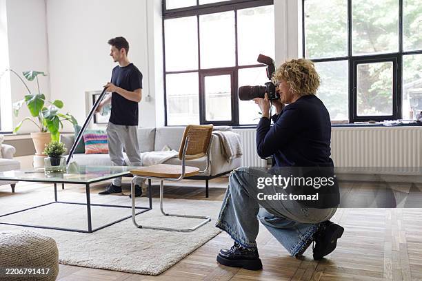 fotógrafa femenina de mediana edad que dispara en un estudio casero - fotógrafo fotografías e imágenes de stock