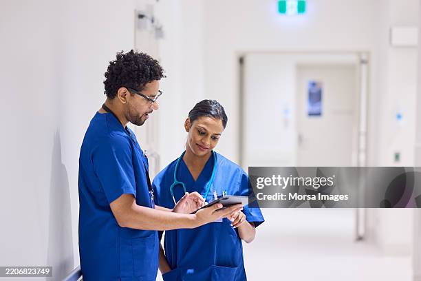 healthcare worker explaining medical records to colleague - male nurse stock pictures, royalty-free photos & images