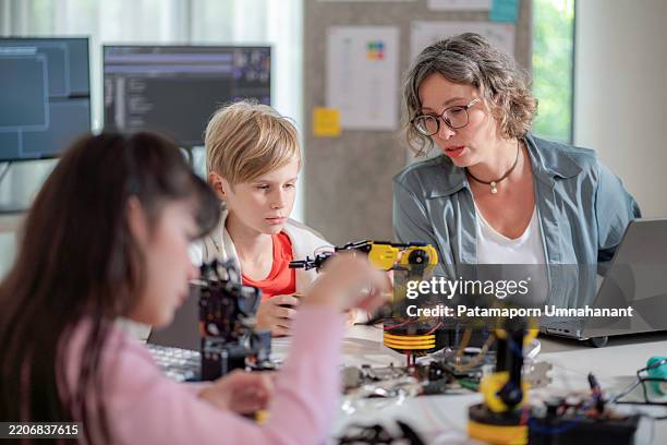 young students in a futuristic classroom engage in hands-on stem learning, experimenting with robotic arms using bluetooth gloves. this interactive session fosters curiosity, creativity, and innovation while enhancing skills in artificial intelligence - prototype stock pictures, royalty-free photos & images