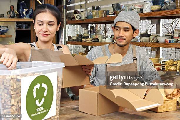 couple packaging recyclable materials in a ceramic workshop - recycled material stock pictures, royalty-free photos & images