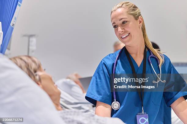 doctora sonriente hablando con el paciente - vestimenta de hospital fotografías e imágenes de stock