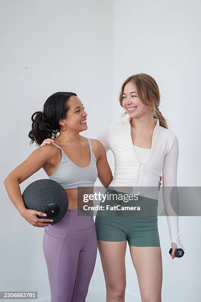 two women engaged in fitness activities together in a bright space - athleisure stock pictures, royalty-free photos & images