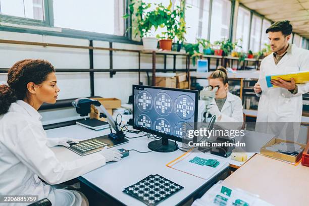 engineers inspecting circuit boards with digital microscopes - electron microscope stock pictures, royalty-free photos & images