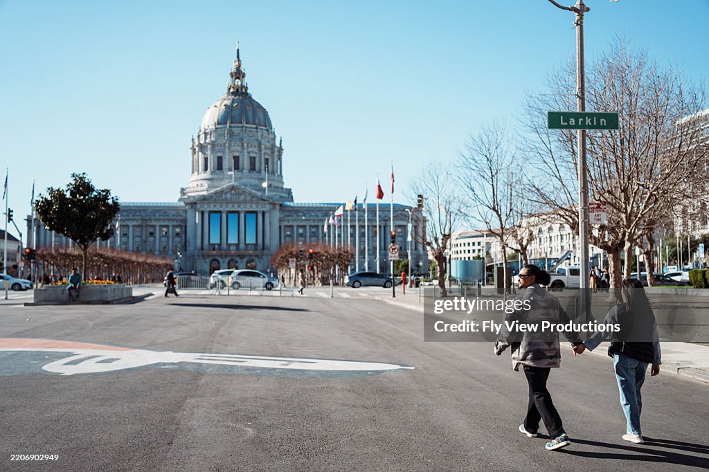 Paar geht die Straße vor dem Rathaus von San Francisco entlang