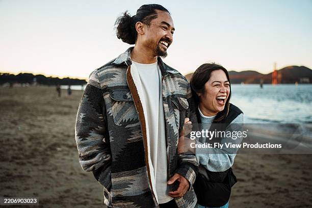 loving filipino couple enjoying time outdoors at the beach - área da baía de san francisco imagens e fotografias de stock