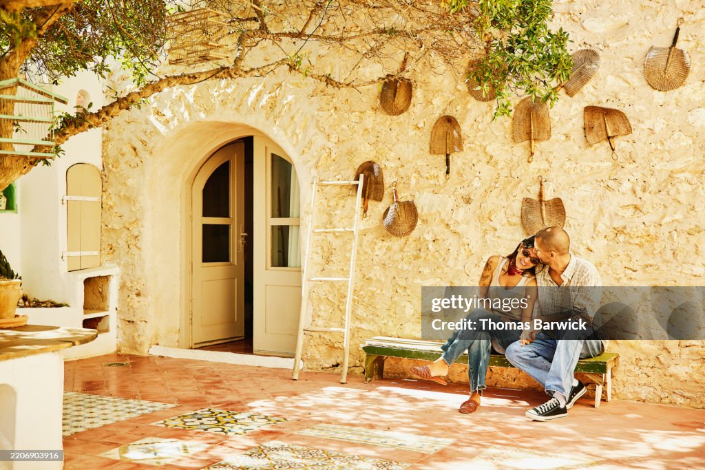 Extreme wide shot couple embracing in courtyard of eco resort