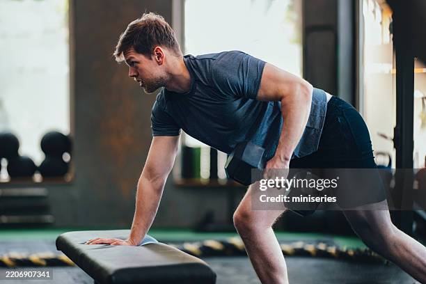 man exercising with dumbbells in a modern gym atmosphere for strength training - hand weight stock pictures, royalty-free photos & images