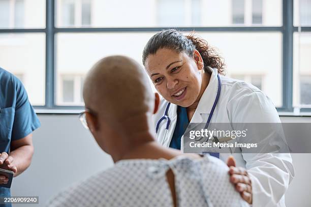 smiling female healthcare expert consoling patient - oncologist stock pictures, royalty-free photos & images
