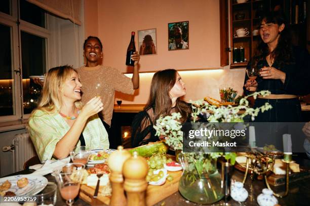 carefree female friends enjoying together at dinner party - dinner party stock pictures, royalty-free photos & images