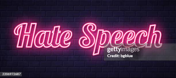 hate speech - glowing neon text on brick wall background - hate stock illustrations