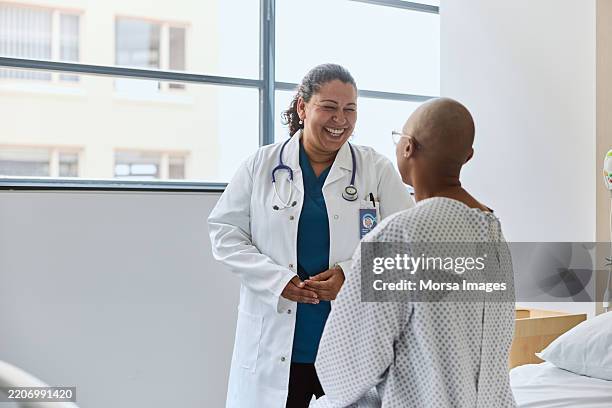 female doctor laughing while discussing with patient - oncologist stock pictures, royalty-free photos & images