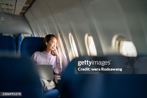 A Business Woman Admires the Scenic Views from her Airplane Window A Business Woman Admires the Scenic Views from her Airplane Window