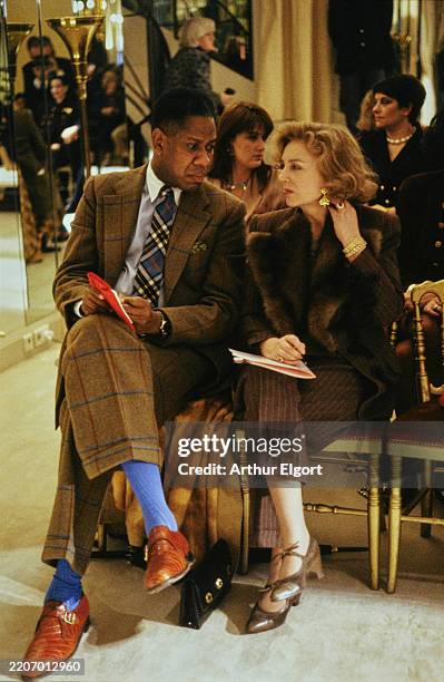 Vogue Editor André Leon Talley sitting beside another attendee at the Chanel couture show in Paris in 1990.