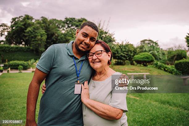 portrait of volunteer with elderly man in nursing home - senior adult male stock pictures, royalty-free photos & images