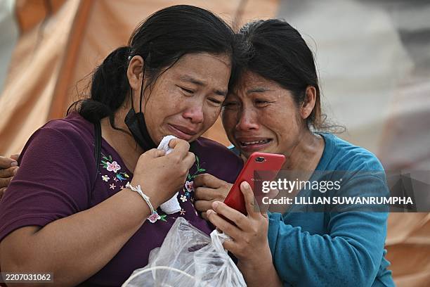Women react after hearing of the death of a relative at the site of an under-construction building collapse in Bangkok on March 30 two days after an...