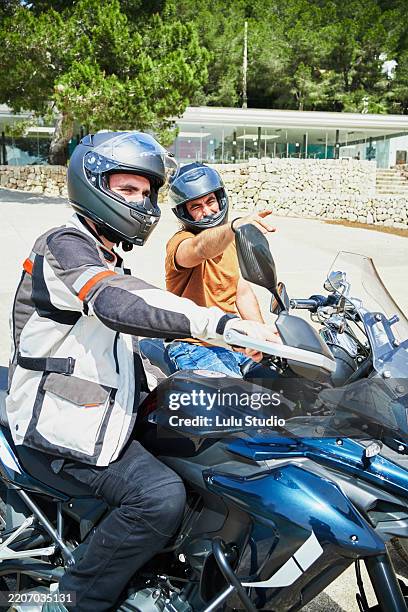 los moteros se preparan para un viaje en moto y hablan de la ruta - motociclista fotografías e imágenes de stock