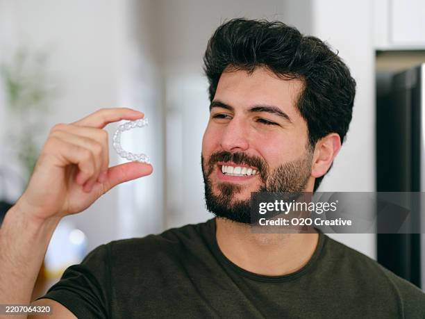 young man with teeth aligner - man white teeth stock pictures, royalty-free photos & images