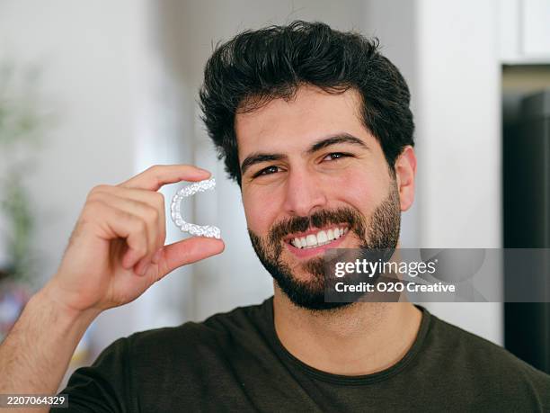 young man with teeth aligner - menselijk gebit stockfoto's en -beelden