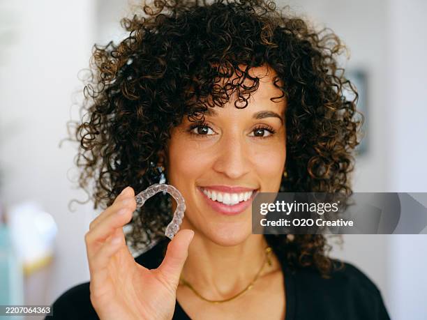 young woman with teeth aligner - aparelho dentário imagens e fotografias de stock