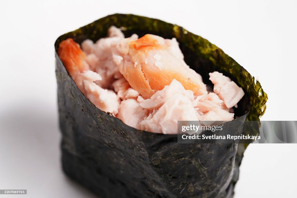 Temaki sushi with flaked salmon and dried seaweed on white background