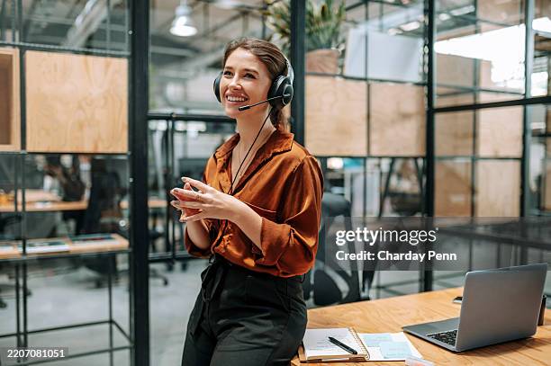 customer support officer with headset, smiling at desk, listening to client in call center - callcenter bildbanksfoton och bilder
