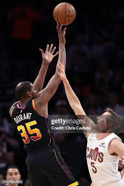 Kevin Durant of the Phoenix Suns shoots over Sam Merrill of the Cleveland Cavaliers during the second half at PHX Arena on March 21, 2025 in Phoenix,...