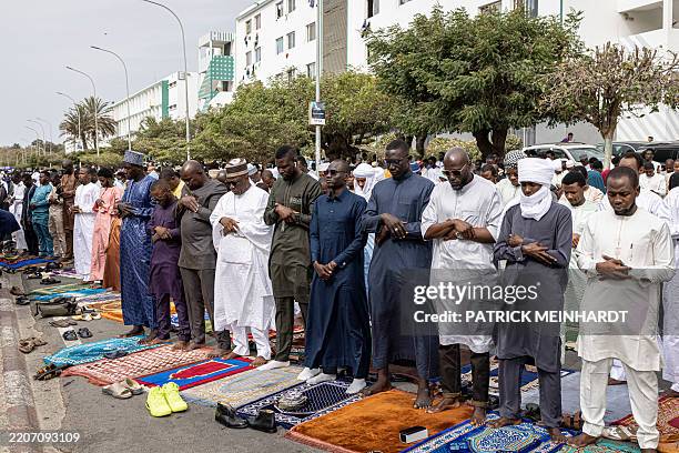 Muslim worshippers pray during the Eid al-Fitr morning prayer at the Universite Cheikh Anta Diop Mosque in Dakar, on March 30, 2025 as Muslims across...