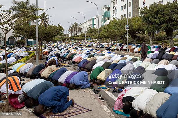 Muslim worshippers pray during the Eid al-Fitr morning prayer at the Universite Cheikh Anta Diop Mosque in Dakar, on March 30, 2025 as Muslims across...
