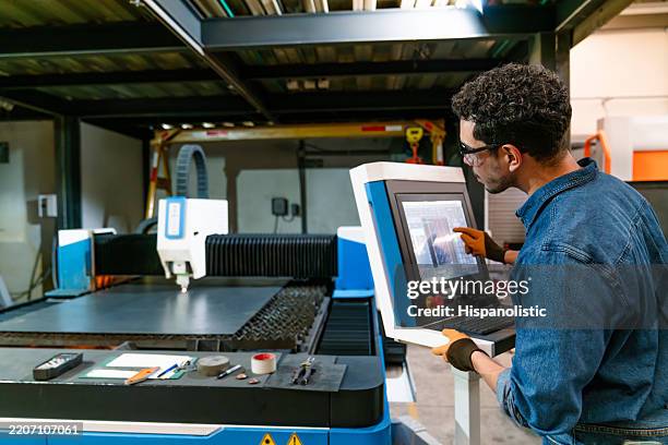 technician operating a laser cutting machine at a metal factory - laser engraving stock pictures, royalty-free photos & images