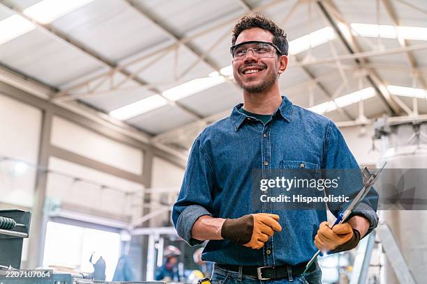 superviseur heureux travaillant dans une usine de métallurgie et souriant - ouvrier photos et images de collection
