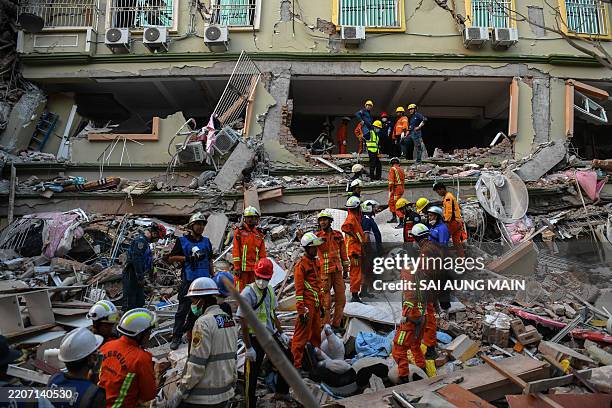 Rescue teams work to evacuate residents trapped under the rubble of the collapsed building 'Sky Villa Condominium development' in Mandalay on March...