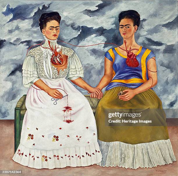 The Two Fridas , 1939. Double self-portrait, depicting two versions of Kahlo seated together. One is wearing a white European style Victorian dress,...