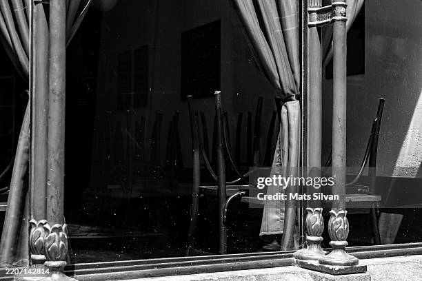 window view on a restaurant with chair and table in a sunny summer day in city - black and white cafe stock pictures, royalty-free photos & images