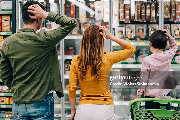 family with shopping cart choosing products in supermarket. - verward stockfoto's en -beelden