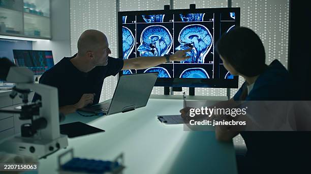 les médecins discutent du cas du patient lors d’une discussion de cas clinique - mutation génétique photos et images de collection