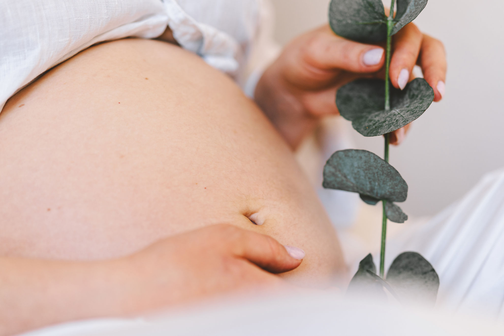 Pregnant woman sitting peacefully on bed in cozy home setting Pregnant woman sitting peacefully on bed in cozy home setting