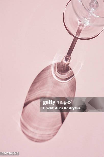 shadow from wine glass on pink background - after party stock pictures, royalty-free photos & images