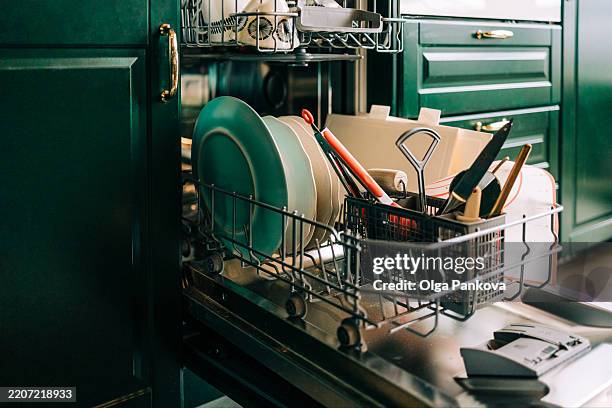 open dishwasher showing dishes and cutlery inside, ready for washing - dishwasher stock pictures, royalty-free photos & images