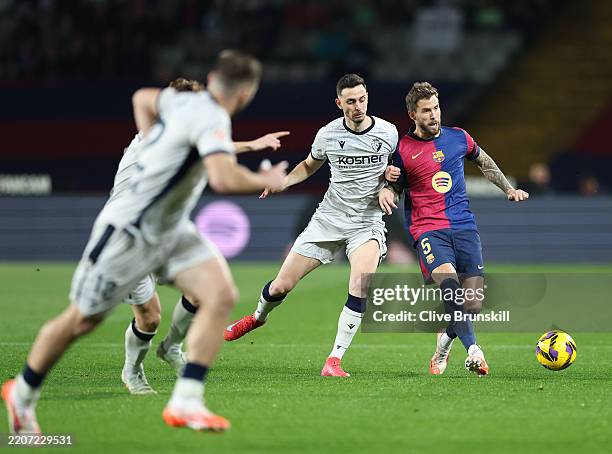 Inigo Martinez of FC Barcelona passes the ball whilst under pressure from Raul Garcia of CA Osasuna during the La Liga EA Sports match between FC...