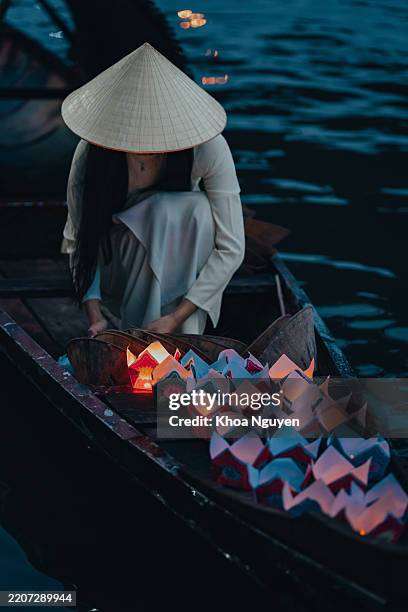 traditional multicolored paper lanterns with candles floating down the river at night and beautiful woman with vietnam culture traditional - traditional vietnam stock pictures, royalty-free photos & images