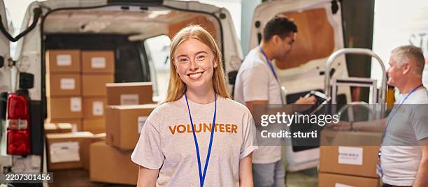 young volunteer co-ordinating food parcel deliveries - charities aid foundation stock pictures, royalty-free photos & images