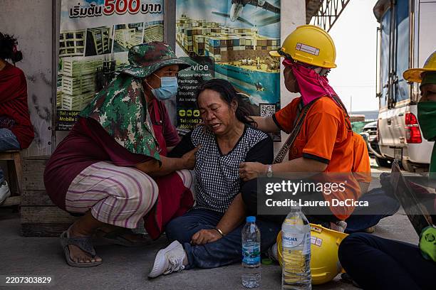 People weep next to a collapsed building near Chatuchak Market following an earthquake on March 28, 2025 in Bangkok, Thailand. A powerful 7.7...