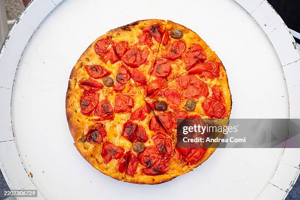 delicious freshly baked pizza with tomatoes and olives on a wooden serving plate - deep dish pizza stock pictures, royalty-free photos & images