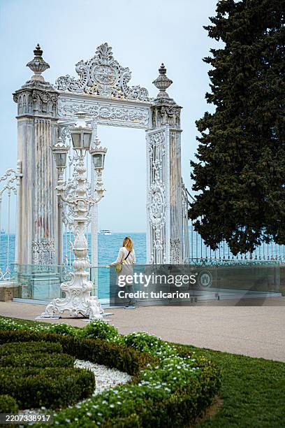 junge frau, die die architektur des dolmabahçe-palastes, istanbul bewundert - sultanahmet-viertel stock-fotos und bilder